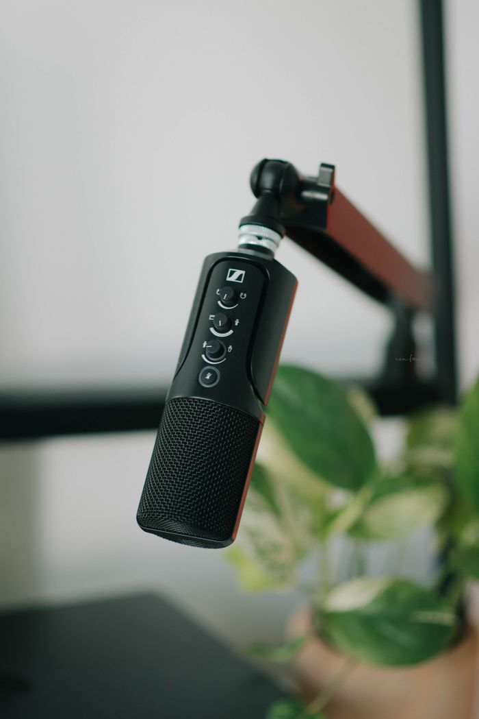 home-img Close-up of a black microphone on a stand, perfect for recording and broadcasting.